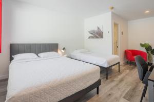 布罗瑟德尚普兰汽车旅馆的一间卧室配有两张床和红色椅子