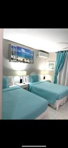 欧丘里欧欧丘里欧度假村的两张位于酒店客房的床,配有蓝色床单