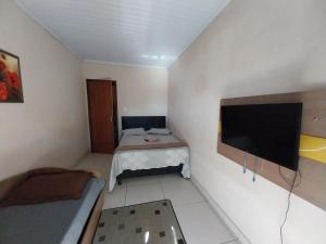 坎普斯戈伊塔卡济斯Casa 4的小房间设有一张床和一台平面电视