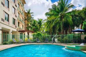 米拉玛劳德代尔堡西南米拉玛尔万怡酒店的棕榈树建筑前的游泳池
