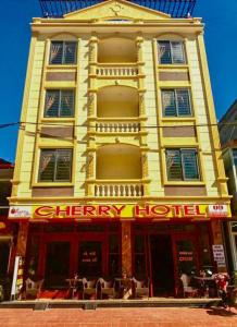 萨帕Cherry Hotel的街上一座黄色的建筑,有一间令人愉快的酒店