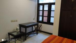 诺伊达Blessings Noida Home stay的小房间设有书桌和窗户