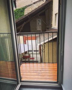 Montalieu-VercieuAppartement Centrale Confort的通往带木甲板的阳台的开放式门