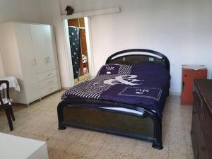 雷霍沃特2 bedroom apartment in batiya makov的一间卧室配有一张床铺,床上有毯子