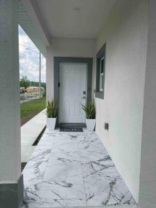 奥兰多3BD/2BTH Home Near Downtown Orlando的一座铺有大理石地板的房屋的前门