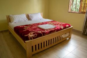 KisoroNtebeko Homestay的卧室内的一张带木框的大床