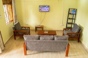KisoroNtebeko Homestay的客厅配有沙发和两把椅子