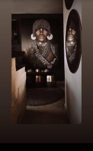 侯斯普瑞特African Flair Boutique Safari Lodge的坐在楼梯上的女人的雕像