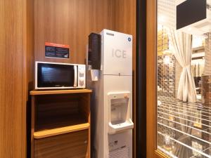 大阪APA Hotel Namba Shinsaibashi Higashi的微波炉和冰箱