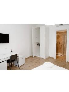 那不勒斯B&b CasaCapaldo的一间空的白色房间,配有书桌和电脑
