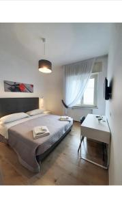 那不勒斯B&b CasaCapaldo的一间卧室配有一张床、一张桌子和一个窗户。