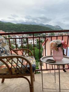伊加洛Apartmani SRNA, Igalo的阳台配有椅子和一张带花瓶的桌子