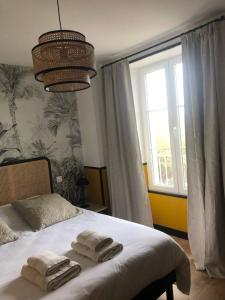 Saint-Vigor-le-GrandDOMAINE DU GRAND CAUGY的一间卧室配有一张床,上面有两条毛巾