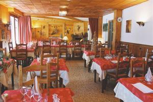 萨莫安斯艾德维斯酒店的餐厅配有桌椅和红色桌布