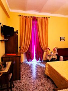 丰迪Bed And Breakfast Camere Primavera的卧室设有窗户和粉红色窗帘