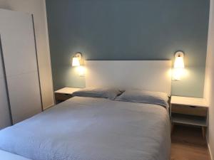 大圣玛丽亚Appartamento Piano terra Prestinone Vigezzo LT的一间卧室配有白色的床和两盏灯
