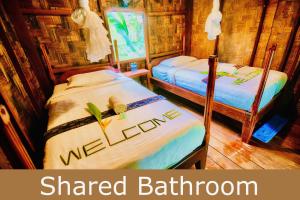 Ban OSpringRiver Resort的宿舍间的两张床,设有共用浴室