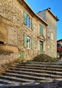 昂迪兹La tour de Pezene的一座古老的石头建筑,设有绿色百叶窗和楼梯