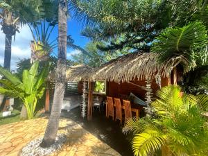 FleurimontBungalow indépendant dans jardin exotique , piscine的一个带桌椅和棕榈树的度假村