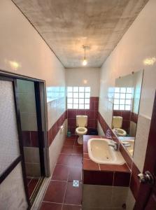 乌尤尼Rummy Hostal的浴室设有2个卫生间、水槽和镜子