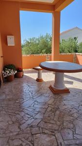 拉布Apartmani Lucia的庭院设有桌子和石头地板。