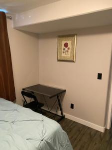 萨斯卡通A cozy 1 bedroom suit的卧室配有一张位于角落的桌子和一张床