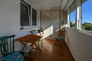 扎达尔Apartment Dada Zadar -Excellent apartment nearby old city的阳台配有木桌和椅子