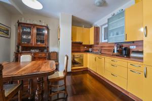 扎达尔Apartment Dada Zadar -Excellent apartment nearby old city的厨房配有黄色橱柜和木桌