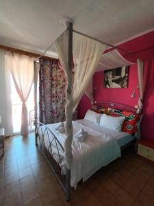 贝尼蔡斯贝尼茨艺术公寓的一间卧室配有一张带粉红色墙壁的天蓬床。