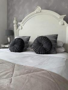 洛斯托夫特月桂树别墅酒店的一张白色的床,上面有两个枕头
