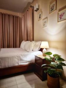达卡Dianella Inn的一间卧室配有一张床和一张植物桌子