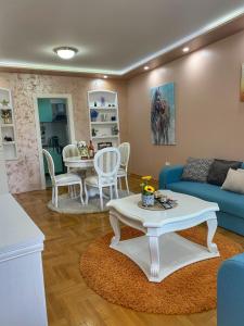 斯雷姆斯卡米特罗维察Apartman Diana的客厅配有蓝色的沙发和桌子