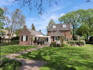 羊角村B&B Villa Giethoorn - canalview, privacy & parking的享有砖房外景,设有庭院