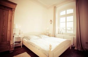 克勒珀林Schloss Altenhagen的白色的卧室设有床和窗户