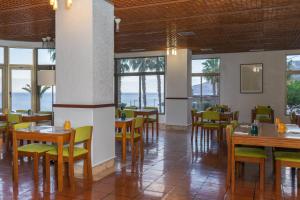 里韦拉布拉瓦Flag Hotel Madeira - Ribeira Brava的用餐室设有桌椅和窗户。