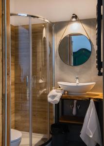 斯克拉斯卡波伦巴Zielony Jeleń - sauna i jacuzzi的带淋浴、盥洗盆和镜子的浴室