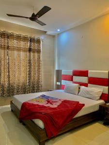 阿姆利则Hotel Sukhman Residency的一间卧室配有一张大床和红色床头板