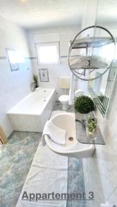 维尔Croadriatic Apartments的浴室配有卫生间、盥洗盆和浴缸。