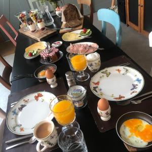 纳尔德韦克B&B Bij tante Teun的桌上放有鸡蛋和橙汁