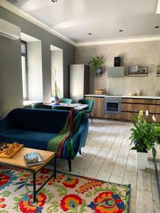 扎波罗热3 Rooms VIP Apartment on Metallurgov 5的一间带蓝色沙发的客厅和一间厨房