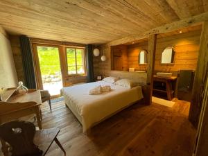 GsteigAlpen Charme - Chalet d'Hôtes et SPA的小木屋内一间卧室,配有一张床
