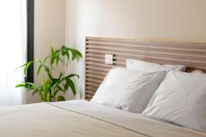 MoranSlowness - Kibbutz Moran的一间卧室配有带白色枕头和植物的床