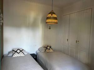 阿尔豪林格朗德Ruim appartement, zonnig terras, Alhaurin Golf!的一间卧室配有两张床和灯具
