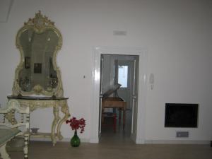 诺沃利B&B A casa delle zie的一间设有镜子的房间和一张带鲜花的桌子
