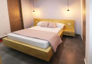 卡利554 Apartments的一间卧室配有一张大床和木制床头板