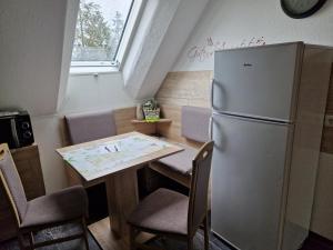 WulkauFerienhaus Schneider的厨房配有桌子和冰箱