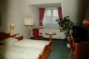 希尔沙伊德布拉恩克拉斯酒店的一间卧室配有一张床、一张桌子和一台电视。