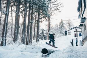 妙高Mountain Hut Myoko的一个人在雪覆盖的斜坡上骑滑雪板