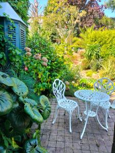 圣布里厄Le Jardin Secret & Spa的庭院配有两把椅子和一张桌子及椅子