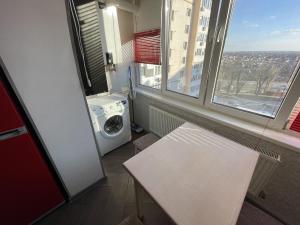 文尼察Studio apartment on Vatutina的洗衣房配有洗衣机和白色长凳